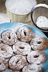 Image showing Fresh baked chocolate chip cookies with sugar powder on blue pla