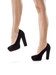 Image showing Tanned female legs in high heels isolated on white background.