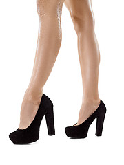 Image showing Tanned female legs in high heels isolated on white background.