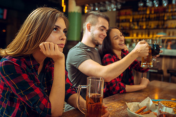 Image showing people, leisure, friendship and communication concept - happy friends drinking beer, talking and clinking glasses at bar or pub