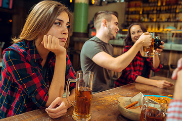 Image showing people, leisure, friendship and communication concept - happy friends drinking beer, talking and clinking glasses at bar or pub