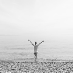 Image showing Happy Carefree Woman Enjoying Sunset Walk on White Pabbled Beach. Black and white photo.