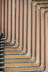 Image showing some copper tubes outside on a wall