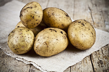 Image showing Fresh organic dirty potatoes heap closeup on linen tablecloth on