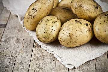 Image showing Fresh organic dirty potatoes heap closeup on linen tablecloth on