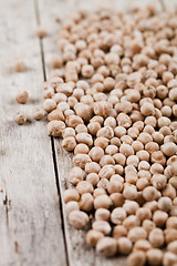 Image showing Dry raw organic chickpeas heap on rustic wooden table background