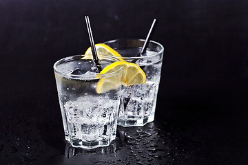 Image showing Two glasses of fresh cold carbonated water with ice cubes and le