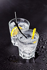 Image showing Two glasses of fresh cold carbonated water with ice cubes and le