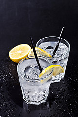Image showing Two glasses of fresh cold carbonated water with ice cubes and le