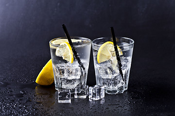 Image showing Glass of fresh cold carbonated water with ice cubes and lemon sl