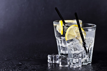 Image showing Glass of fresh cold carbonated water with ice cubes and lemon sl