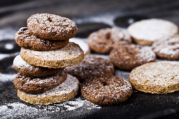 Image showing Chocolate chip and oat fresh cookies with sugar powder stack.
