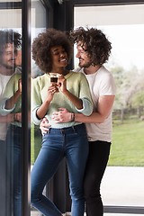 Image showing happy multiethnic couple relaxing at modern home indoors