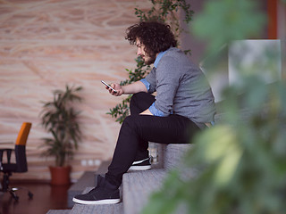 Image showing Young casual businessman holding smartphone