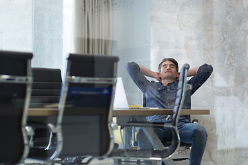 Image showing young businessman relaxing at the desk