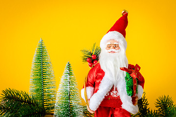 Image showing Santa Claus figure with fir trees on yellow background