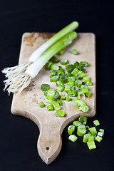 Image showing Fresh green organic chopped onions on a cutting board.