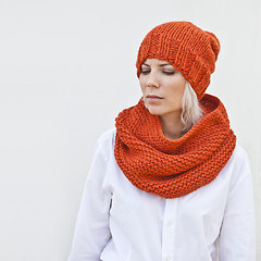 Image showing Pretty young woman in warm orange knitted hat and snood.