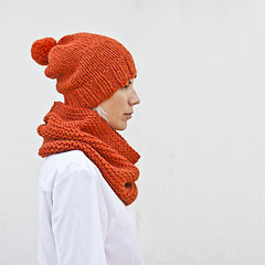 Image showing Pretty young woman in warm orange knitted hat and snood. 