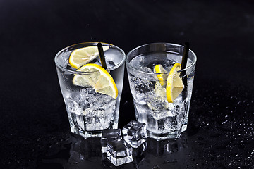 Image showing Glasses of fresh cold carbonated water with ice cubes and lemon 