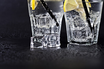 Image showing Glasses of fresh cold carbonated water with ice cubes and lemon 