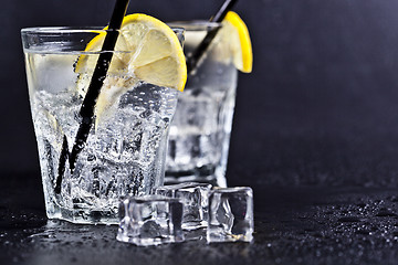 Image showing Glasses of fresh cold carbonated water with ice cubes and lemon 