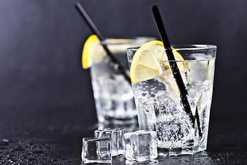 Image showing Glasses of fresh cold carbonated water with ice cubes and lemon 