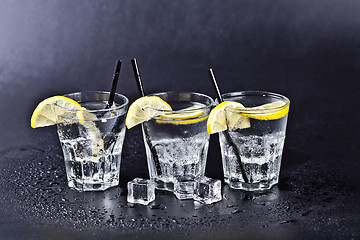 Image showing Three glasses of fresh cold carbonated water with ice cubes and 