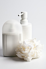 Image showing Bath cosmetic products and white sponge on light background.