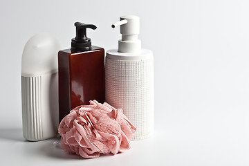 Image showing Bath cosmetic products and white sponge on light background.