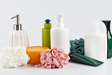 Image showing Bath cosmetic products set and sponges on light background. 