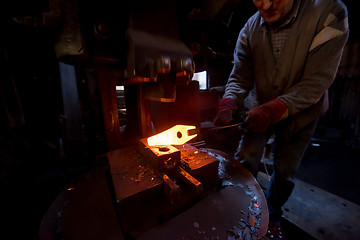 Image showing blacksmith manually forging the molten metal