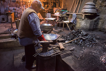 Image showing traditional blacksmith manually forging the molten metal