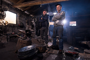 Image showing portrait of two generations confident blacksmith