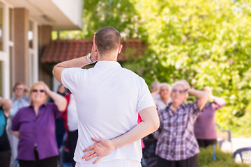 Image showing trainer training motivated active healthy senior people