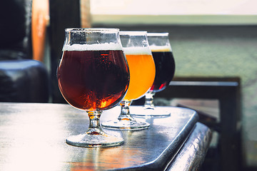 Image showing Glasses of different kinds of beer on wooden background