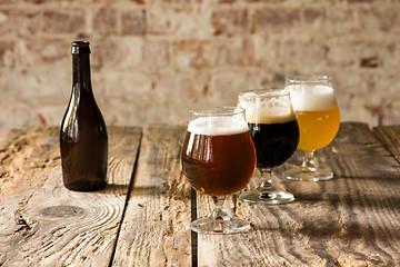 Image showing Glasses of different kinds of beer on wooden background