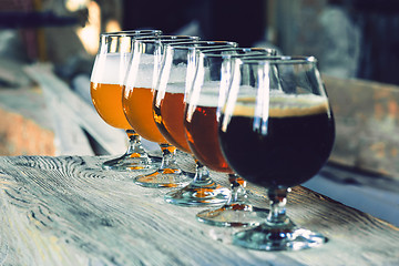 Image showing Glasses of different kinds of beer on wooden background