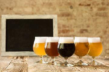 Image showing Glasses of different kinds of beer on wooden background