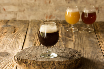 Image showing Glasses of different kinds of beer on wooden background