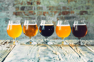 Image showing Glasses of different kinds of beer on wooden background