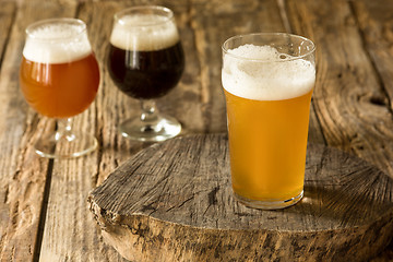 Image showing Glasses of different kinds of beer on wooden background