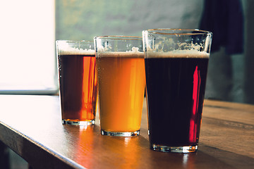 Image showing Glasses of different kinds of beer on wooden background