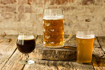 Image showing Glasses of different kinds of beer on wooden background