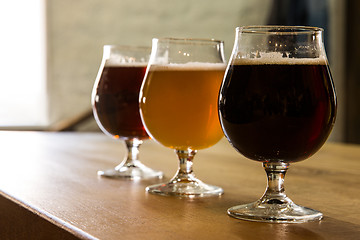 Image showing Glasses of different kinds of beer on wooden background