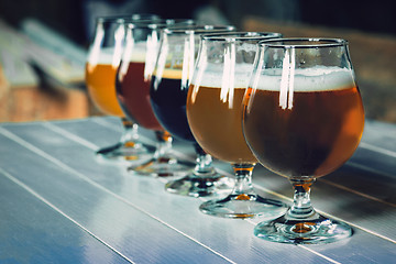 Image showing Glasses of different kinds of beer on wooden background