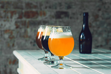 Image showing Glasses of different kinds of beer on wooden background