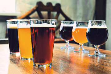 Image showing Glasses of different kinds of beer on wooden background