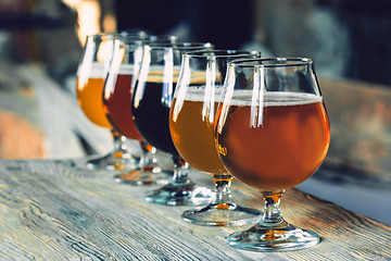 Image showing Glasses of different kinds of beer on wooden background