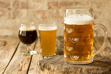 Image showing Glasses of different kinds of beer on wooden background